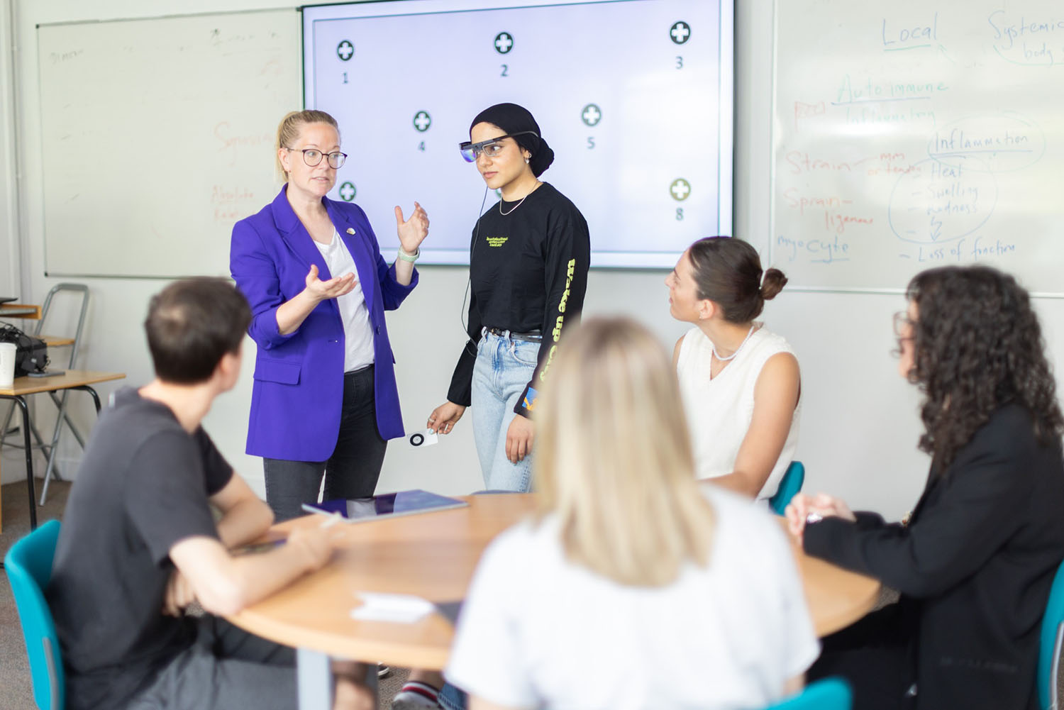 A student with a teacher explaining a piece of equipment.