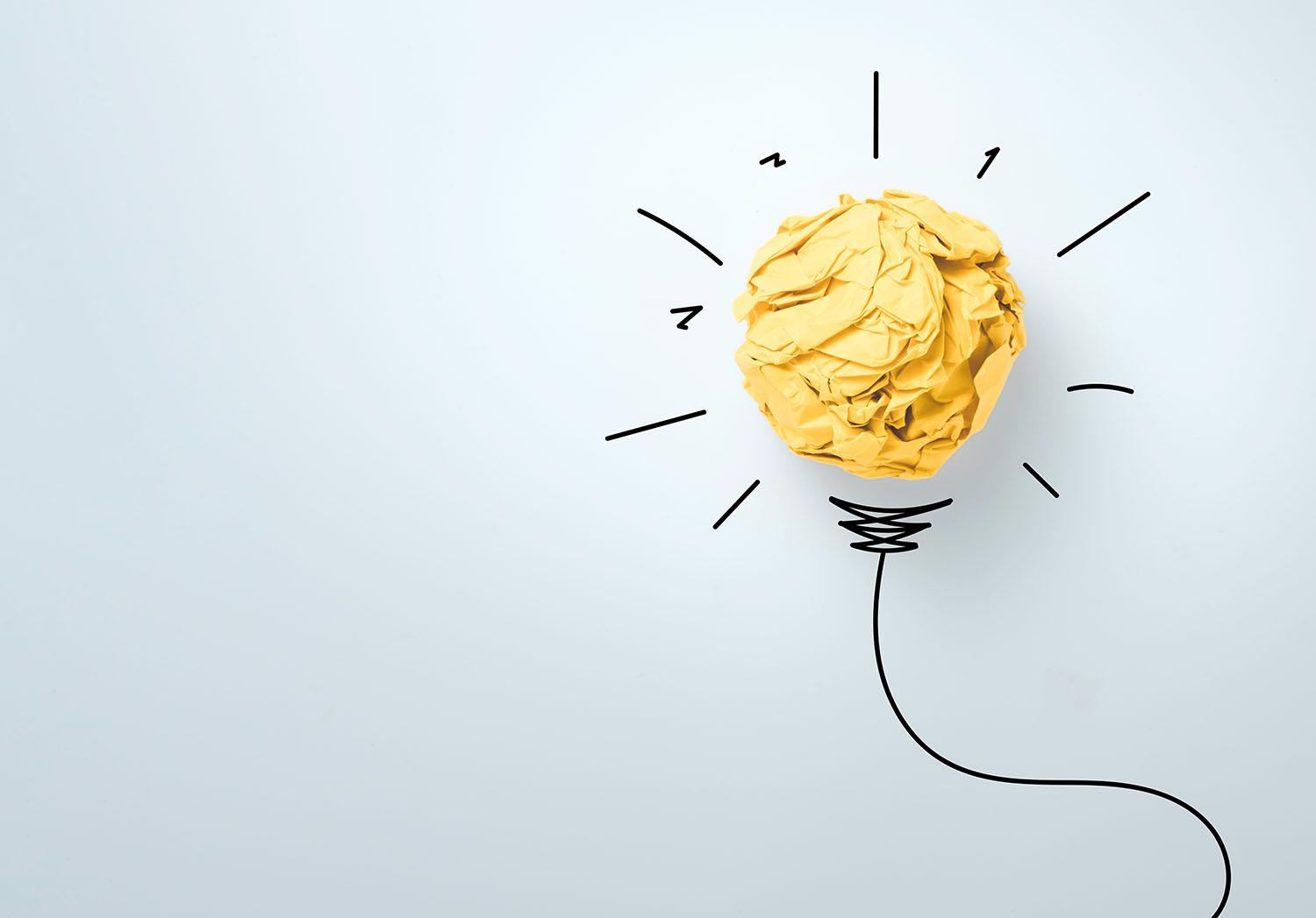 a light bulb, made of paper with an illustration behind it.