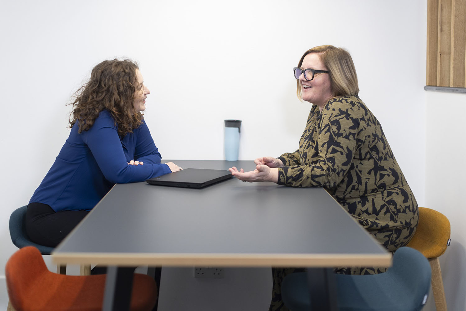 Two people at a table are chatting.