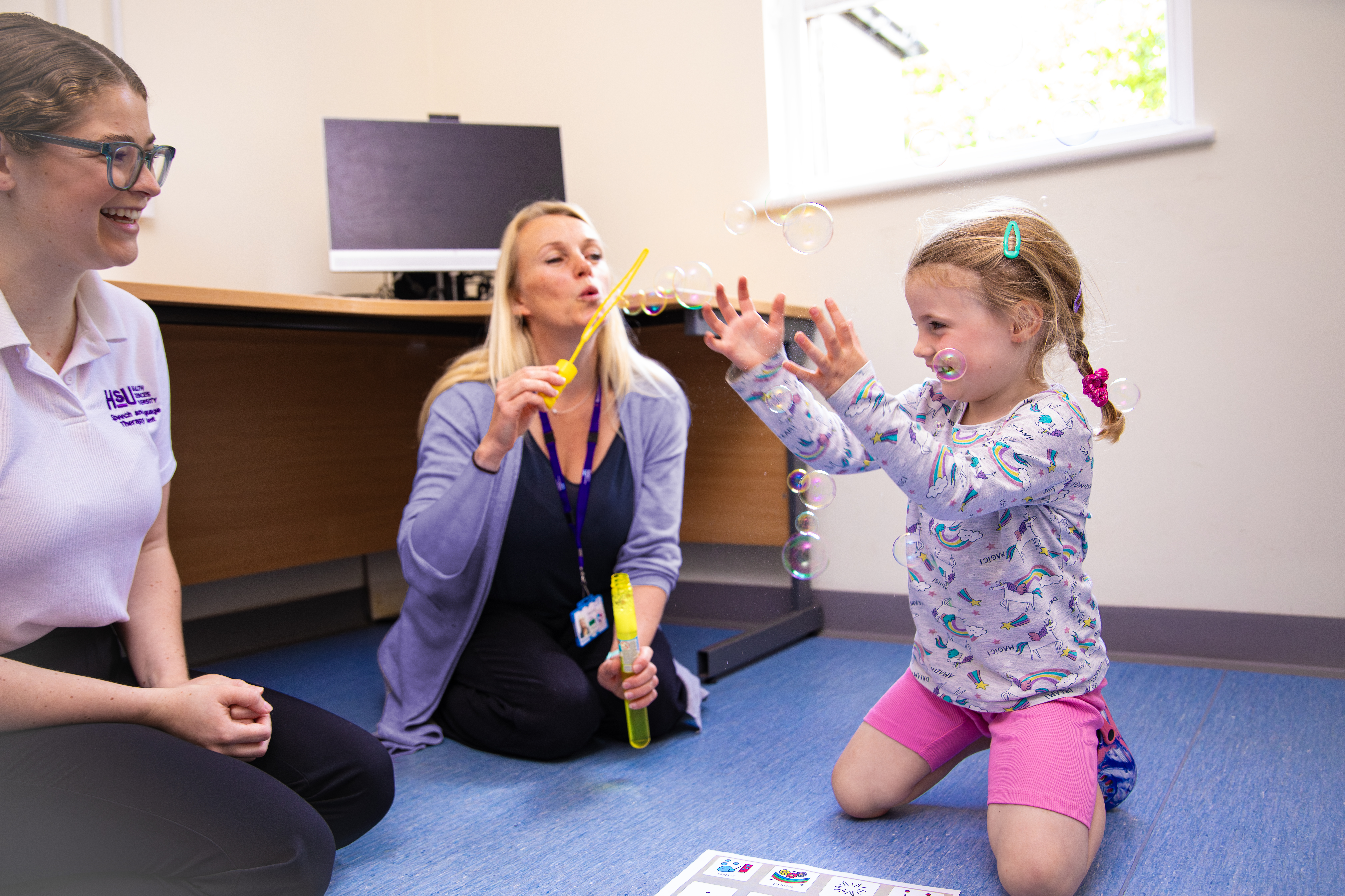 Two people and a baby playing with bubbles