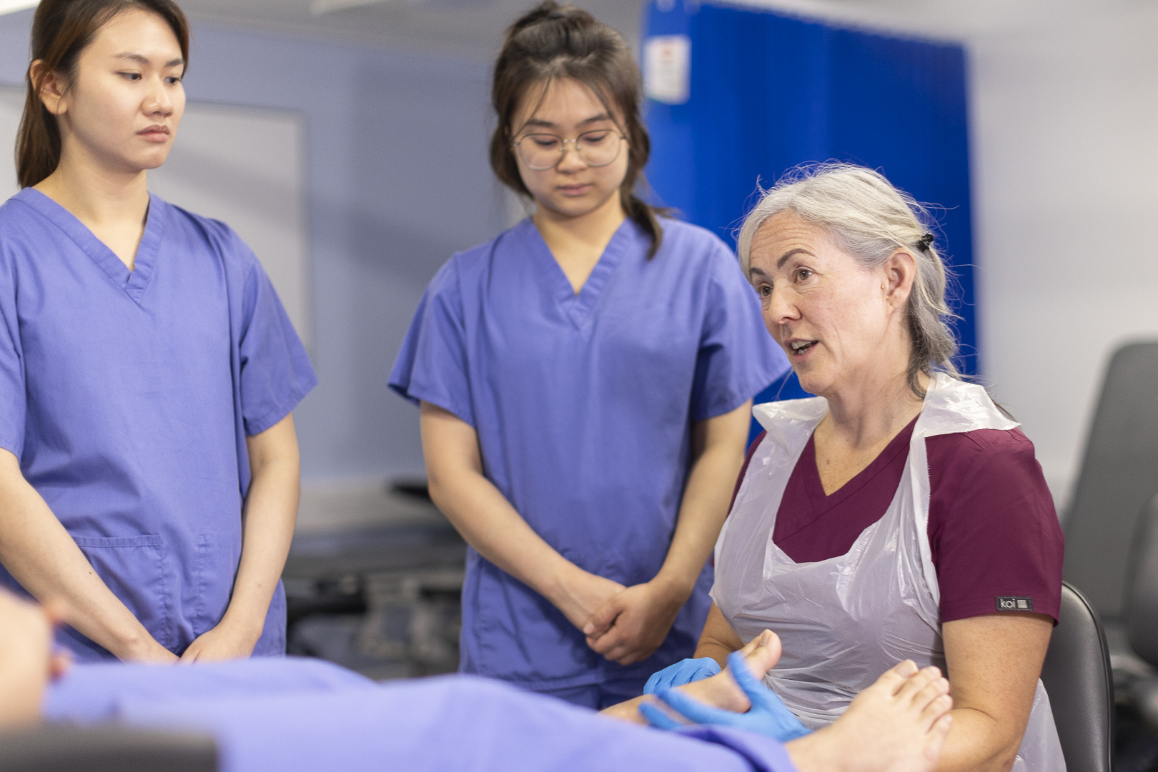 a demonstration with a podiatry patient and students.