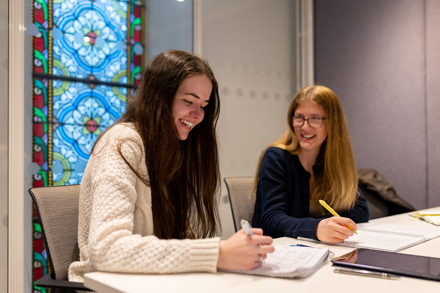 Image of two students working at a desk.